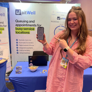 WaitWell conference with Cassidy holding a phone with the mobile view of WaitWell